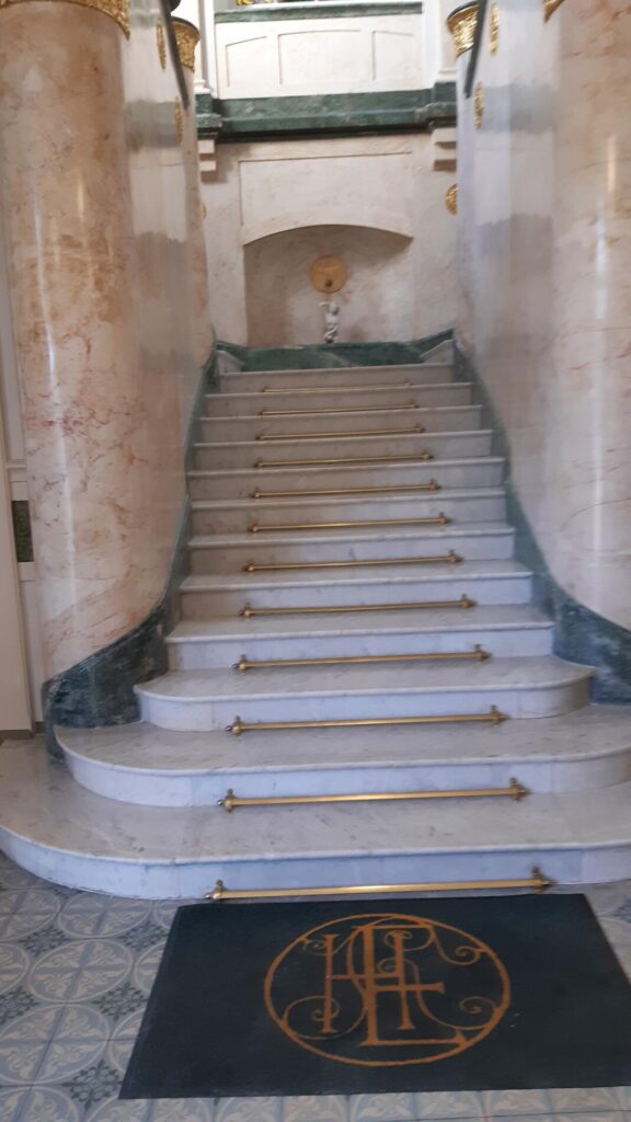 Photo d'un escalier en marbre blanc avec quelques touches de doré - PC MARBRE